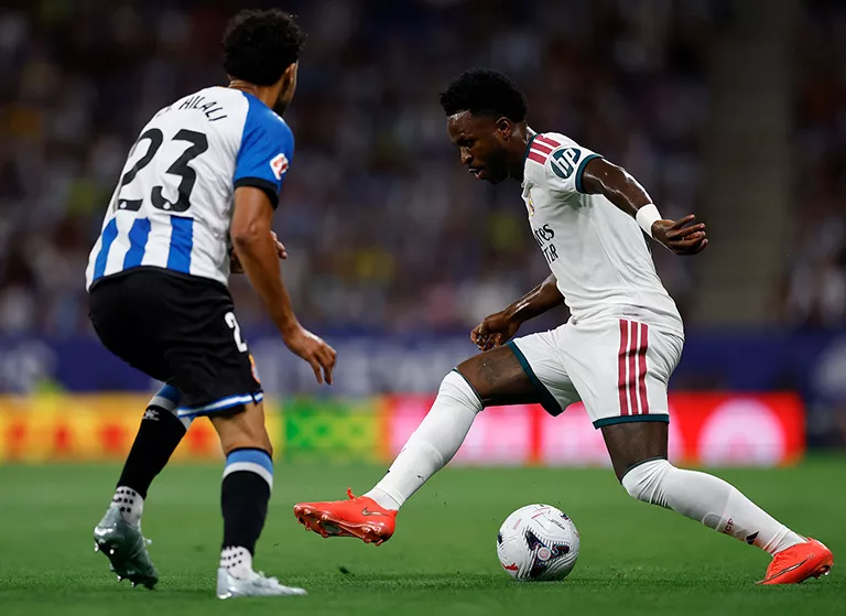 Vinicius regateando a un rival con el Real Madrid
